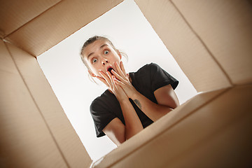 Image showing Woman unpacking and opening carton box and looking inside