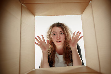 Image showing Woman unpacking and opening carton box and looking inside