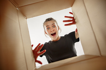 Image showing Woman unpacking and opening carton box and looking inside