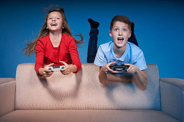 Image showing Computer game competition. Gaming concept. Excited girl playing video game with joystick