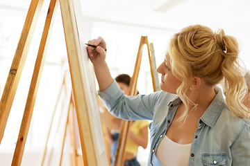 Image showing woman with easel drawing at art school studio