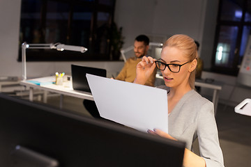 Image showing businesswoman with papers working at night office