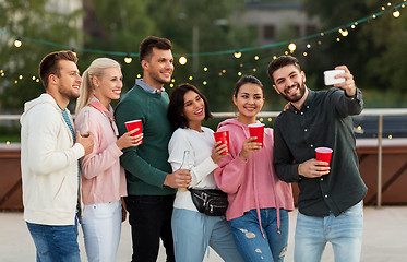 Image showing friends with drinks taking selfie at rooftop party