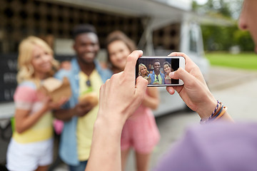 Image showing man taking picture of friends eating at food truck