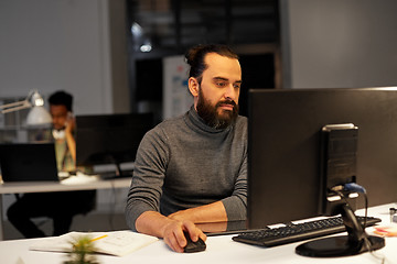 Image showing creative man with computer working at night office