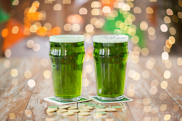 Image showing glasses of green beer and gold coins on table