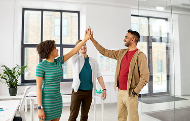 Image showing happy creative team making high five at office