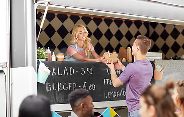 Image showing saleswoman at food truck serving male customer