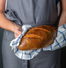 Image showing Artisanal wheat loaf in the hands of women.