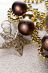 Image showing Christmas golden and brown decorations closeup on glitter backgr