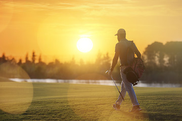 Image showing handsome middle eastern golfer carrying bag and walking to next 