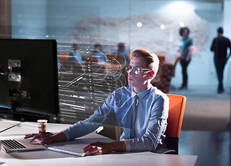 Image showing man working on computer in dark office