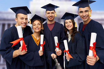 Image showing happy graduates with diplomas taking selfie