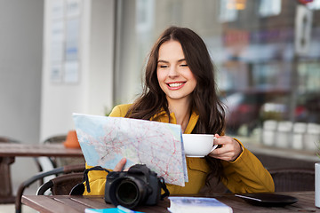 Image showing happy woman with map drinking cocoa at city cafe