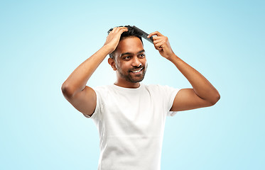 Image showing happy indian man brushing hair with comb