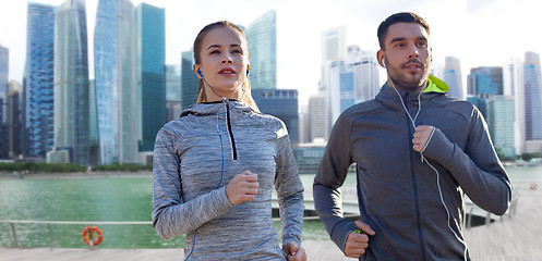 Image showing couple with earphones running over singapore 