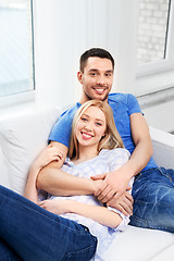 Image showing happy couple sitting on sofa and hugging at home