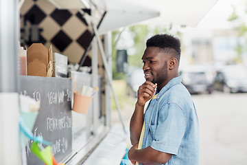 Image showing male customer looking at billboard at food truck