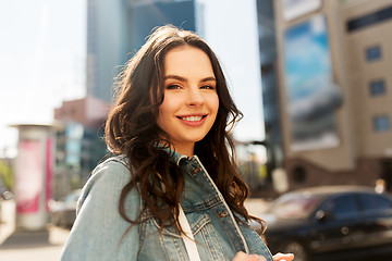 Image showing happy smiling young woman on summer city street