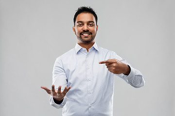 Image showing indian businessman holding something invisible