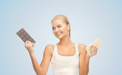 Image showing woman choosing between dark and white chocolate