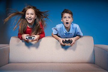 Image showing Computer game competition. Gaming concept. Excited girl playing video game with joystick