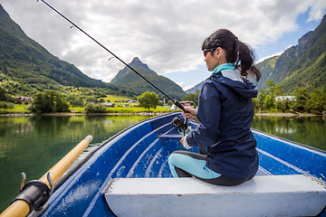 Image showing Woman fishing on Fishing rod spinning in Norway.