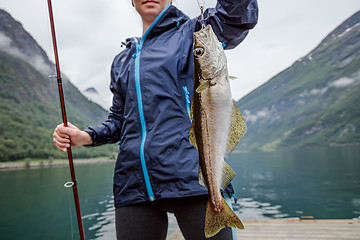 Image showing Woman fishing on Fishing rod spinning in Norway.