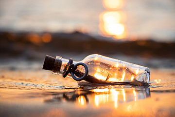 Image showing Message in the bottle against the Sun setting down