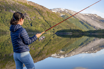 Image showing Woman fishing on Fishing rod spinning in Norway.