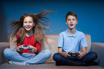 Image showing Computer game competition. Gaming concept. Excited girl playing video game with joystick