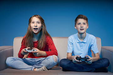 Image showing Computer game competition. Gaming concept. Excited girl playing video game with joystick