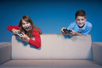 Image showing Computer game competition. Gaming concept. Excited girl playing video game with joystick