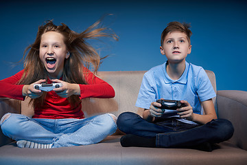 Image showing Computer game competition. Gaming concept. Excited girl playing video game with joystick