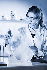 Image showing Young scientist pipetting in life science laboratory.