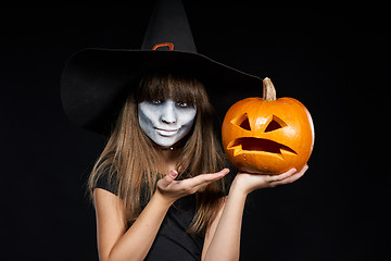 Image showing Halloween witch girl showing Jack-O-Lantern pumpkin on palm