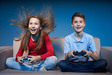 Image showing Computer game competition. Gaming concept. Excited girl playing video game with joystick