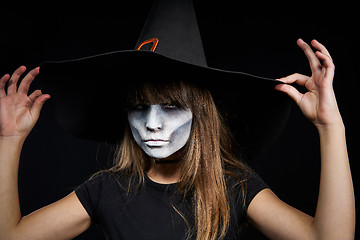 Image showing Closeup of Halloween witch girl looking at camera on black background.