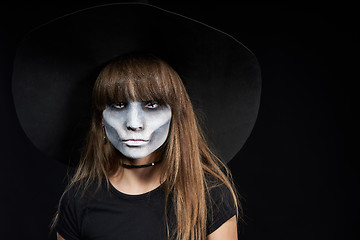 Image showing Closeup of Halloween witch girl looking at camera on black background.