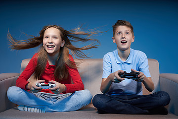 Image showing Computer game competition. Gaming concept. Excited girl playing video game with joystick