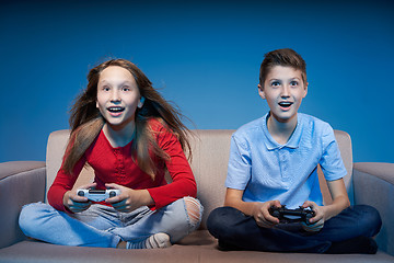 Image showing Computer game competition. Gaming concept. Excited girl playing video game with joystick