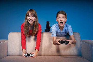 Image showing Computer game competition. Gaming concept. Excited girl playing video game with joystick