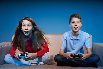 Image showing Computer game competition. Gaming concept. Excited girl playing video game with joystick