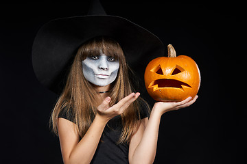 Image showing Halloween witch girl showing Jack-O-Lantern pumpkin on palm