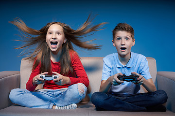 Image showing Computer game competition. Gaming concept. Excited girl playing video game with joystick