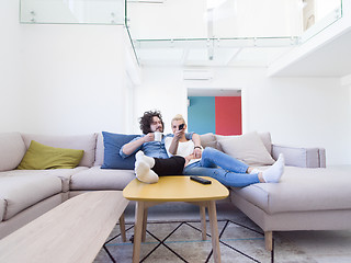 Image showing Young couple on the sofa watching television