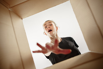 Image showing Woman unpacking and opening carton box and looking inside