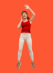 Image showing Full length of pretty young woman with mobile phone while jumping