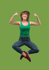 Image showing Freedom in moving. Pretty young woman jumping against orange background