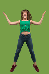 Image showing Freedom in moving. Pretty young woman jumping against orange background